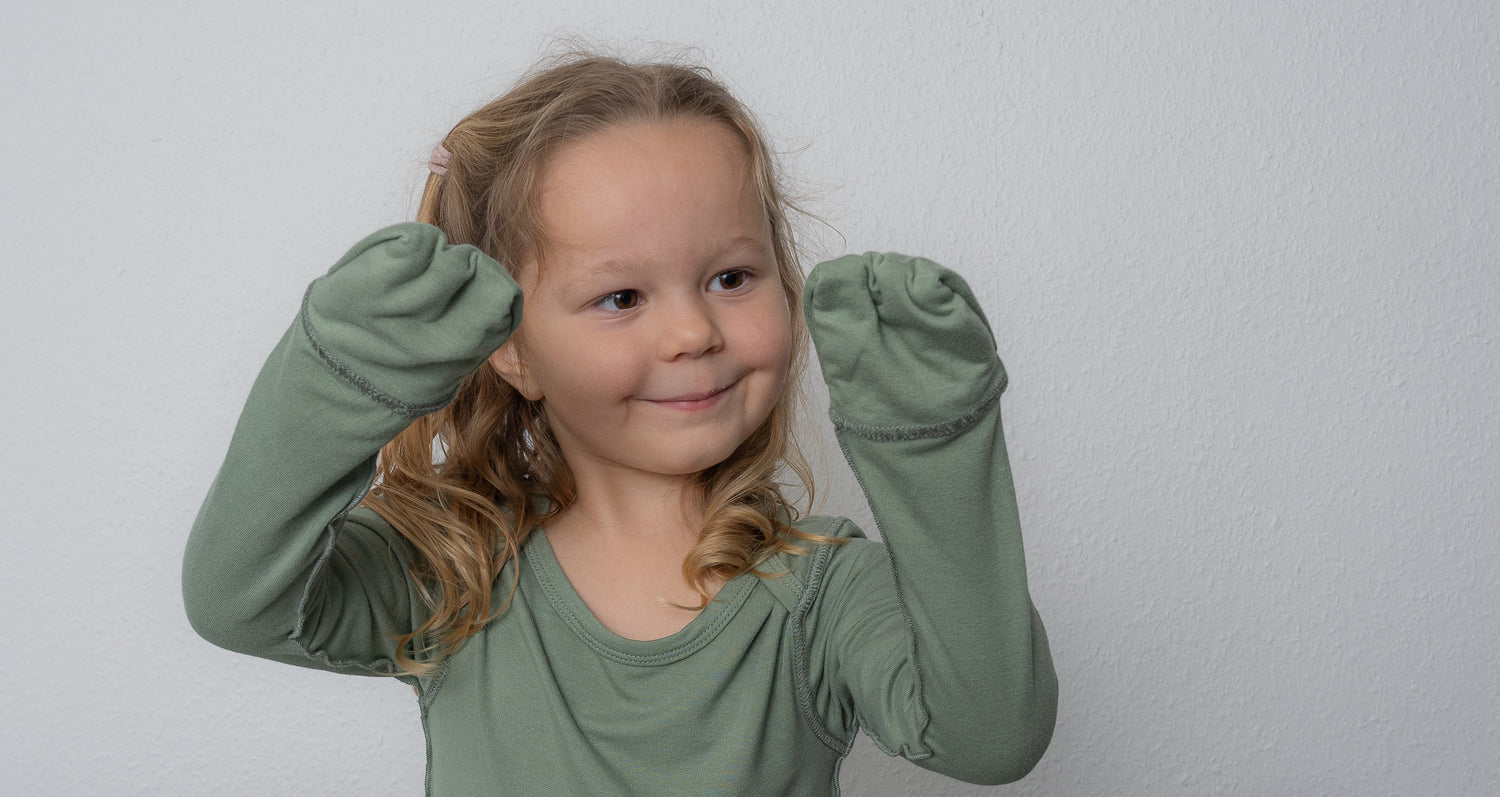 Girl Showing Off SOOTHLA Baby Bodysuit With Foldable Anti-scratch Mittens