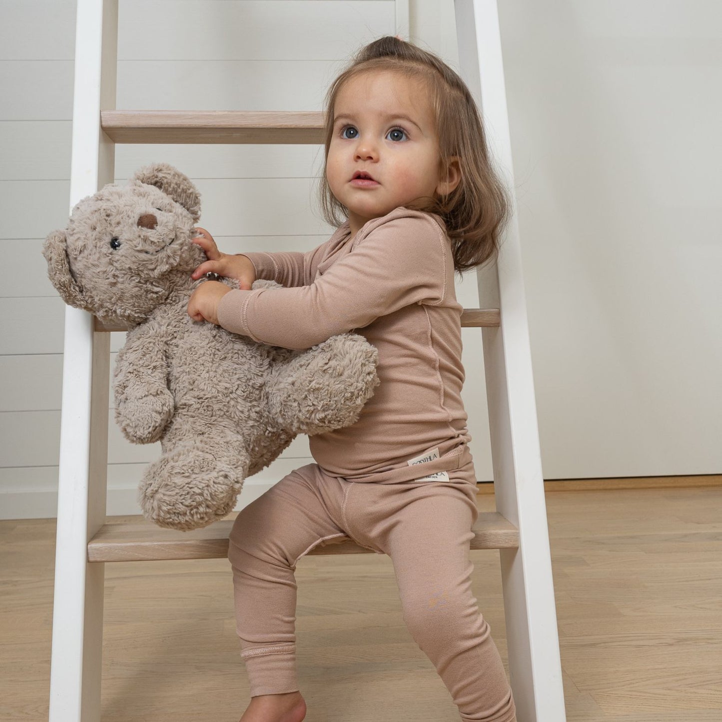 Girl Sitting On Ladder In SOOTHLA Allergy-friendly Clothing. 